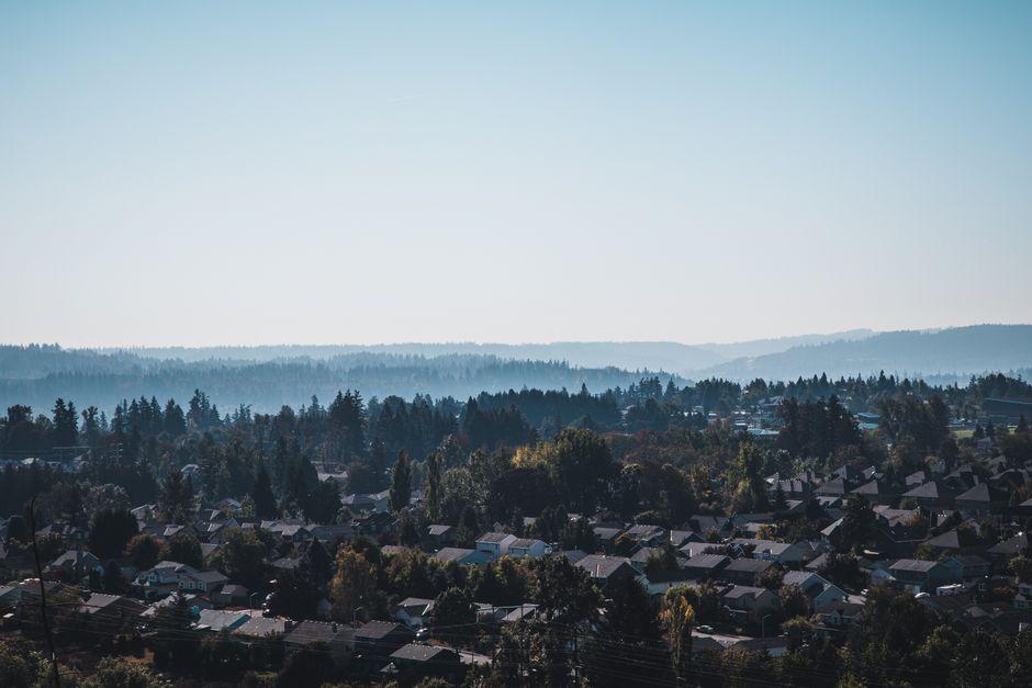 Aerial View of a Town Surrounded by Forest Covered Hills